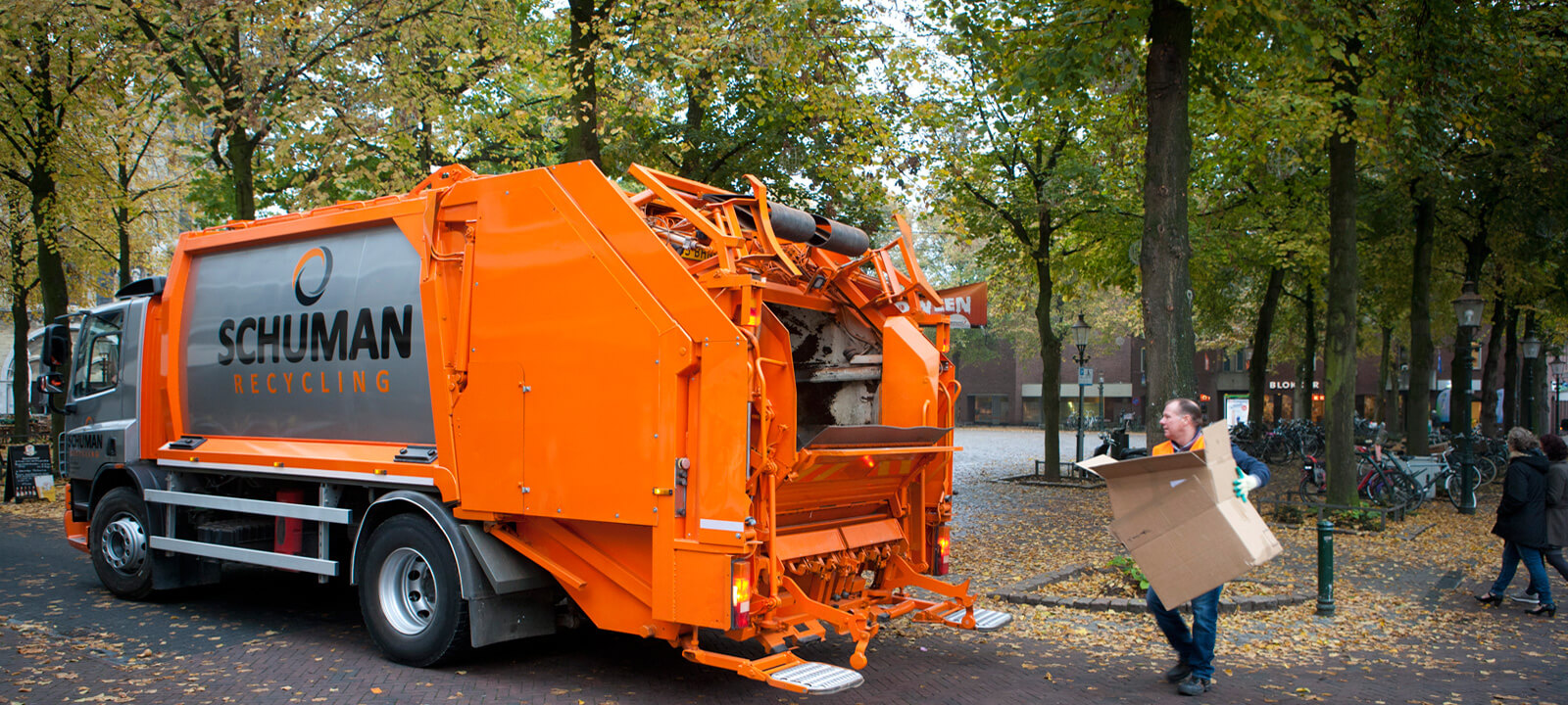 Oranje vuilniswagen van Schuman Recycling in het centrum van Roermond