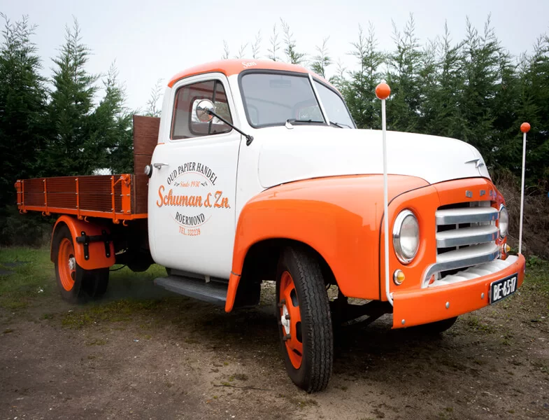 De oude oranje-witte Schuman & Zn. oud-papierwagen uit Roermond, sinds 1930
